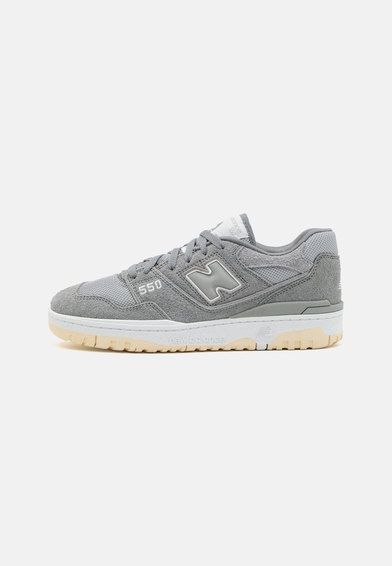Baskets New Balance 550 grises avec dessus en suède et mesh, semelle intermédiaire blanche, semelle extérieure en gomme et logo "N" sur le côté.