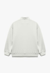 Lysegrå, blød sweatshirt med høj krave, sænkede skuldre og ribbede manchetter. Enkelt, sømløst bagdesign uden udsmykninger.