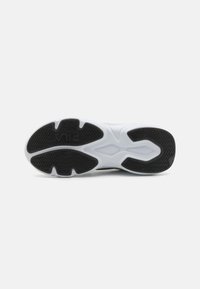 Black and white athletic shoe sole with patterned black rubber traction and a white cushioning base, featuring grooves for flexibility.