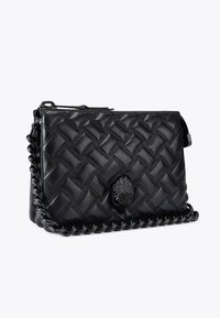 Borsa a mano in pelle nera con motivo intrecciato, dotata di una tracolla a catena e di una chiusura decorativa a forma di mano sul davanti.