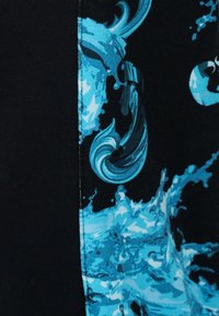 Μπλε και μαύρο ύφασμα με κυματιστό μοτίβο νερού και κυμάτων, χωρισμένο με εμφανή ραφή.