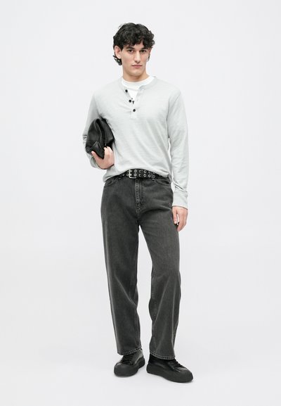 Jasnoszara, długosleeve'owa koszula henley z trzema guzikami, czarny pasek z srebrnymi oczkami, ciemnoszare dżinsy prostego kroju oraz czarne trampki.