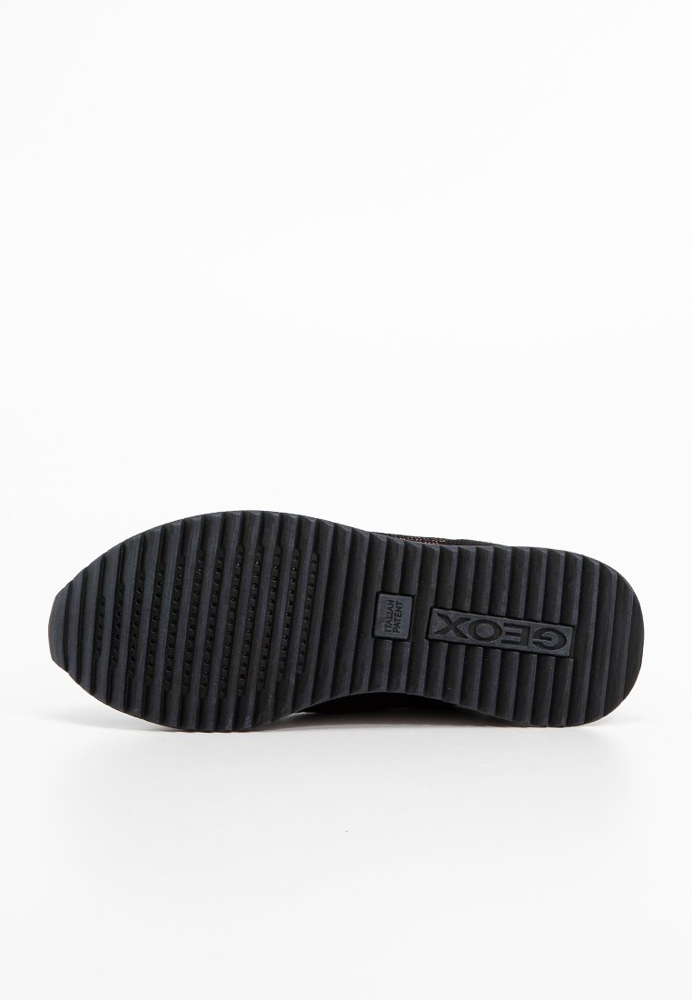 Schwarze Gummisohle mit horizontalen und vertikalen Rillen für besseren Halt, umgeben von einem glatten Rand und mit eingraviertem "Geox"-Logo in der Mitte.
