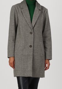 Abrigo de patrón houndstooth en gris y blanco con solapas acentuadas, dos botones, bolsillos laterales y mangas largas. Fabricado con un tejido texturizado.
