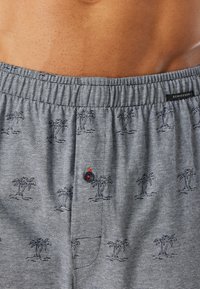 Boxers gris avec un motif de palmier. Fabriqués en tissu doux, avec une taille élastique, un détail à bouton et un design à rayures subtiles.