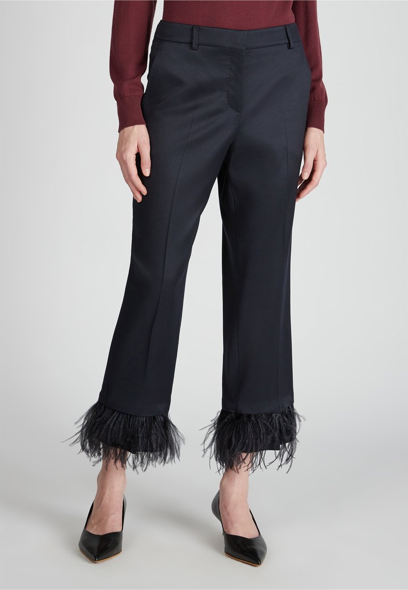 Pantaloni blu navali su misura con rifinitura in piuma nera all'orlo, caratterizzati da una texture liscia e abbinati a tacchi a punta neri.