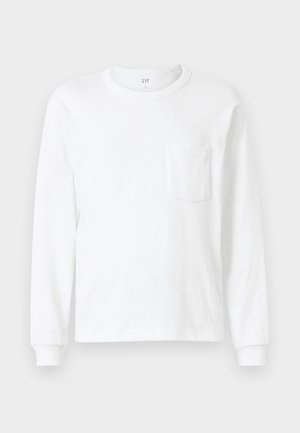 T-shirt bianco a maniche lunghe in cotone. Presenta un collo rotondo e una piccola tasca sul petto. Texture morbida con polsini a costine.