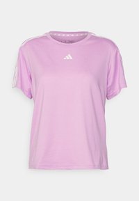 Camiseta deportiva de color púrpura claro con mangas cortas, cuello redondo y acentos de tres rayas blancas en los hombros. Presenta un pequeño logo blanco en el pecho.