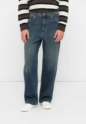 Jeans in denim blu scuro con una linea dritta, caratterizzati da una leggera texture sfrangiata e il classico stile a cinque tasche.