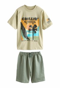 T-shirt beige à manches courtes avec un motif de palmier et de skateboard, associé à un short à taille élastique à rayures verticales vertes et blanches.