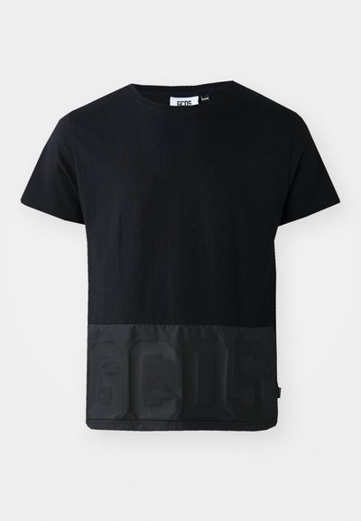 Schwarzes T-Shirt mit einem kontrastierenden, glänzenden schwarzen Einsatz am Saum, der die erhabenen Buchstaben "GCDS" zeigt. Hergestellt aus weichem Stoff mit lockerer Passform.
