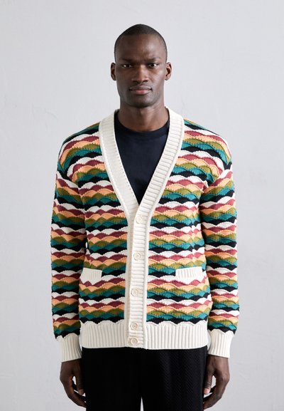 Mehrfarbige gestrickte Strickjacke mit V-Ausschnitt und Knopfverschluss. Sie weist ein geometrisches Muster in Grün, Rot, Gelb und Blau auf. Rippbündchen an den Ärmeln und am Saum.