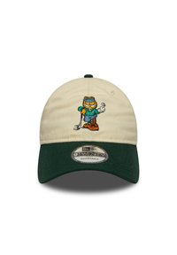 Gorra ajustable con cuerpo de algodón crema y visera verde. Presenta un personaje de dibujos animados bordado con atuendo deportivo, sosteniendo una bola de golf.