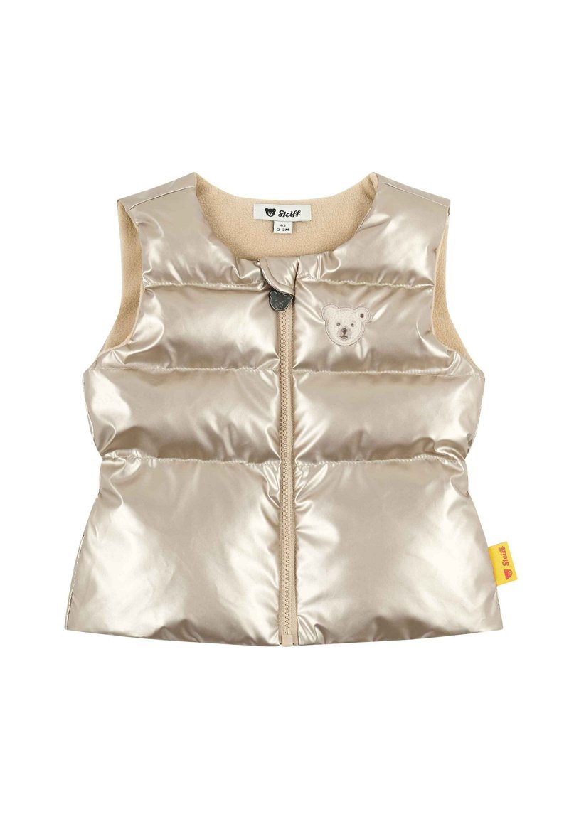 Chaleco acolchado beige con un acabado brillante y logo de oso. Presenta una cremallera frontal, diseño sin mangas y forro suave. Fabricado con materiales sintéticos.