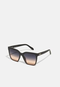 Black rectangular sunglasses with gradient brown lenses, featuring a thick frame and branding on the side. Matte finish and angular design.