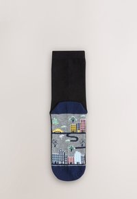 Chaussette en coton noire avec une section inférieure grise à motif représentant des bâtiments et des arbres aux couleurs pastel ; bordée d'une finition bleu foncé au niveau des orteils.