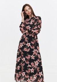 Black floral maxi dress with pink and green flower pattern, long sleeves, ruffled hem, and high neckline, made from lightweight fabric.