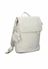 Sac à dos en tissu blanc avec un rabat repliable, des bretelles réglables et un charme en forme de fleur amovible. Texture lisse, design simple.
