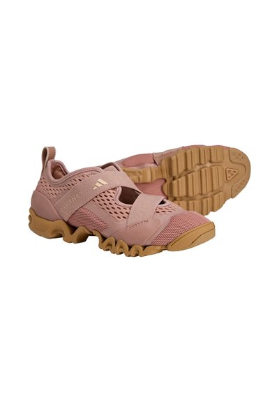 Pink athletic shoes featuring a breathable mesh upper, a textured rubber sole, and a Velcro strap across the midfoot for secure fit.