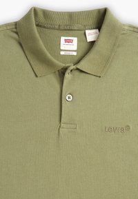 Polo majica maslinaste boje od pamuka, s klasičnim ovratnikom, plaketom na tri dugmeta i izvezenim Levi's logotipom na prsima.