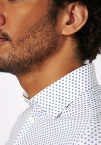 Witte shirt met een blauw cirkelpatroon, een button-down kraag en een soepele textuur, die een moderne pasvorm en gedetailleerde stiksels laat zien.