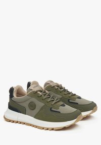Zielone siateczkowe sneakersy z beżowymi akcentami, okrągłym logo, wyściełanym kołnierzem i gumowymi podeszwami. Posiadają system sznurowania zapewniający bezpieczne dopasowanie.