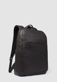 Zwarte leren rugzak met een gladde textuur, een slanke rechthoekige vorm, een ritsvak aan de voorkant en gewatteerde schouderbanden.