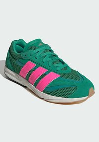 Zelené športové tenisky so zvrškom z sieťoviny, ružovými akcentmi a dizajnom troch pruhov. Majú gumovú podrážku a textúrované materiály pre lepšiu priľnavosť.