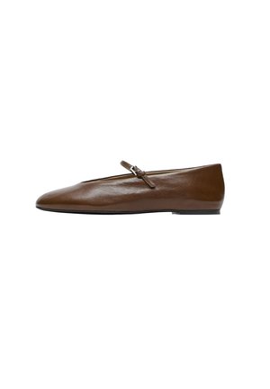 Chaussure plate Mary Jane en cuir marron avec une fine bride et une petite boucle argentée, présentant un bout pointu et une semelle plate noire.