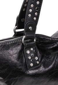 Sac à main en cuir noir avec fermeture éclair, orné de strass noirs et transparents cloutés sur la bandoulière et anneaux métalliques fixant la poignée.