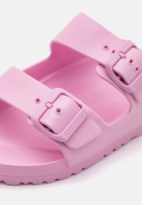 Infradito Birkenstock rosa con due fascia regolabili, realizzate in materiale EVA testurizzato, dotate di fibbie e di una soletta sagomata.