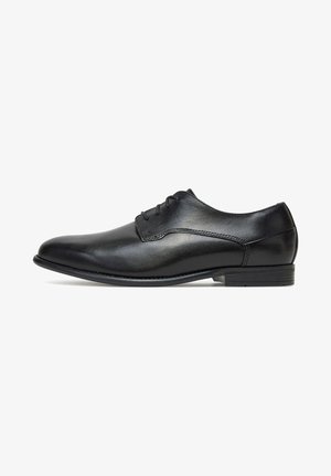 Zwarte leren nette schoen met een gladde afwerking, afgeronde neus, veterontwerp en lage hak. Voorzien van subtiele stikselaccenten.