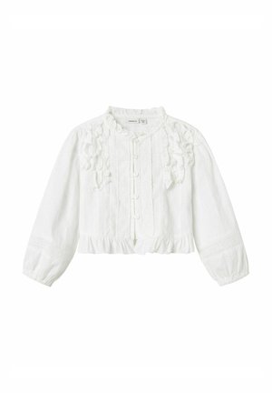 Blouse blanche cropped en tissu texturé, avec des accents à volants, fermeture à boutons et manches longues. Dispose d'un col rond et de finitions décoratives.