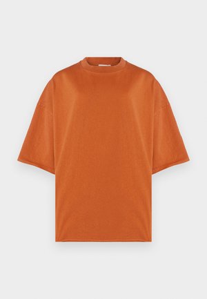 T-shirt oversized de manga curta numa tonalidade laranja quente. Feito de tecido suave com decote redondo e detalhes sutis de costura.