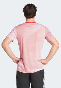 Punainen ja valkoinen ruudullinen lyhythihainen urheilupaita, jossa on pyöreä kaula-aukko, sileä pinta ja lievä gradation-hyvin olkapäillä.