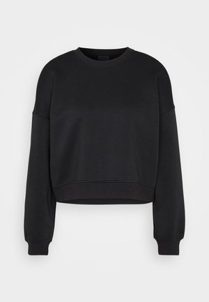 Černý dlouhý rukáv zkrácený svetr s crew neck a žebrovanými manžetami a spodním lemem na jednoduchém světle šedém pozadí.