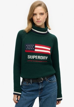 Groene gebreide trui met een col, voorzien van een Amerikaans vlagontwerp en "SUPERDRY" in witte tekst. Geaccentueerd met marineblauwe en witte strepen.