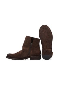 Hnědé semišové kotníkové boty se zipovým uzavíráním, kulatou špičkou a texturovanou gumovou podešví. Má vyšitý detail podél okraje.