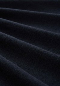 Ciemnoniebieska tkanina o miękkiej, gładkiej fakturze, z delikatnymi falami i zagnieceniami, prezentująca jednolite zabarwienie bez wzorów czy akcentów.