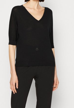 Schwarzes gestricktes Top mit V-Ausschnitt, kurzen Ärmeln und einem kleinen dekorativen Knopf in der Mitte. Weicher Stoff und lockere Passform.
