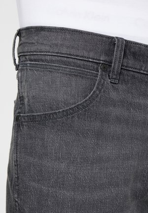 Szare dżinsy z denimu o teksturowanym wykończeniu, z klasycznym pięciopocketowym krojem i metalowymi detalami. Pętle na pasek w talii.