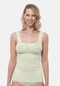 Light green camisole featuring a lace upper section, wide straps, and a soft, textured cotton body. Designed with a fitted silhouette.