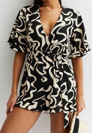 Czarny kombinezon z falistym beżowym wzorem, dekoltem w kształcie V, krótkimi falbankami i paskiem do wiązania w talii. Materiał ma gładką teksturę.