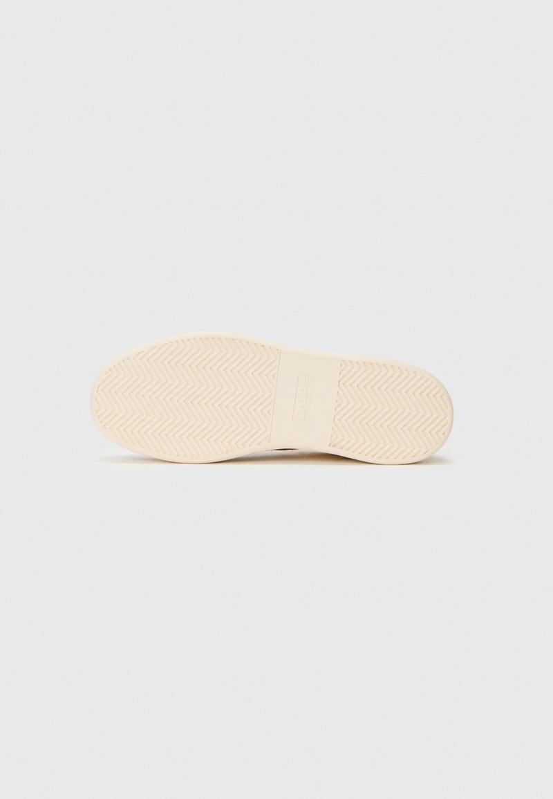 Semelle de chaussure en caoutchouc beige clair avec un motif en chevrons, texture lisse et détail de logo central, conçue pour l'adhérence et la durabilité.