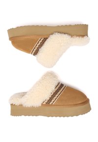 Beige Wildlederschlupfschuhe mit einem flauschigen crema Innenfutter und einer strukturierten Gummisohle. Dekorative braune und weiße Nähte entlang der Oberseite.
