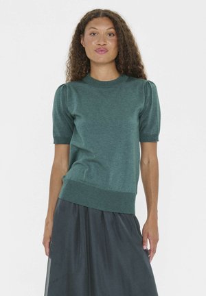 Grüner kurzärmeliger Strickpullover mit rundem Ausschnitt, geripptem Saum und dezenten Puffärmeln. Getragen mit einem dunklen Rock.