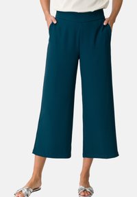 Teal wide-leg pants with pockets, made from a smooth fabric, featuring a comfortable waistband and straight hems for a relaxed fit.