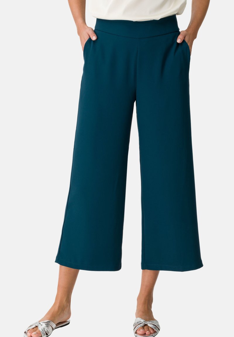 Teal wide-leg pants with pockets, made from a smooth fabric, featuring a comfortable waistband and straight hems for a relaxed fit.