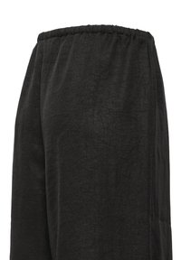 Pantalon ample gris foncé avec une taille élastique en tissu doux et texturé.