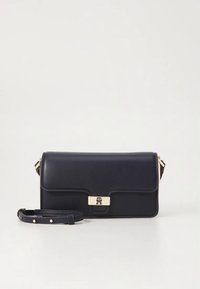 Laivastonsininen nahkainen käsilaukku, jossa on kullanvärinen lukko, litteä muotoilu ja irrotettava olkahihna. Ominaisuuksiin kuuluu minimaalinen ompelu ja logoyksityiskohta lukossa.